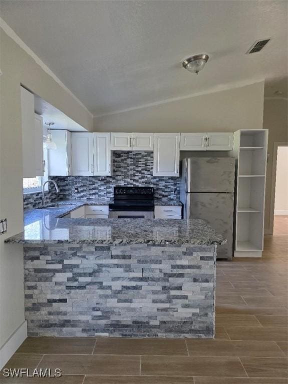 kitchen featuring visible vents, lofted ceiling, appliances with stainless steel finishes, wood tiled floor, and stone counters
