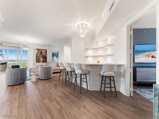 kitchen featuring a breakfast bar area, hardwood / wood-style floors, decorative light fixtures, and an inviting chandelier