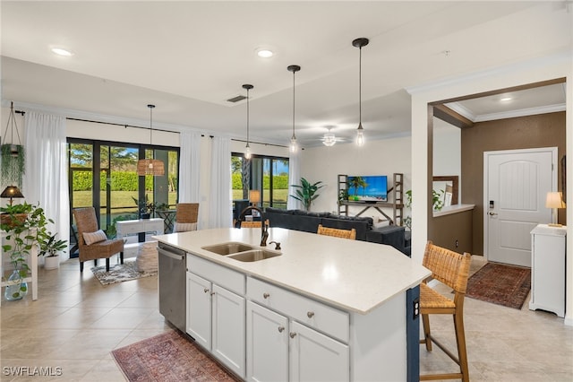 kitchen featuring pendant lighting, dishwasher, white cabinets, sink, and an island with sink