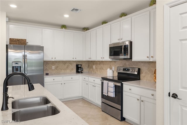 kitchen with backsplash, white cabinetry, sink, and appliances with stainless steel finishes