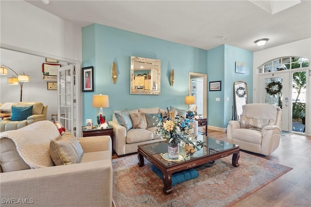 living area featuring baseboards, wood finished floors, and french doors