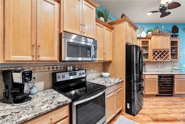 2270 Palo Duro Blvd, North Fort Myers, FL 33917 - kitchen with appliances with stainless steel finishes, light brown cabinetry, beverage cooler, tasteful backsplash, and light wood-style flooring