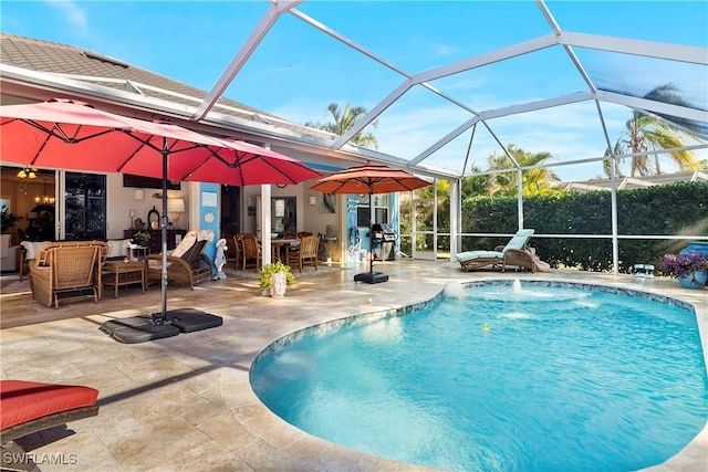 view of swimming pool with pool water feature, a lanai, a patio area, and a grill