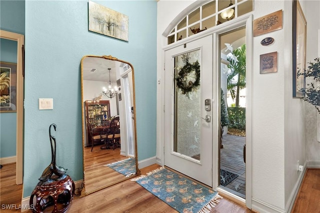 doorway with hardwood / wood-style flooring and an inviting chandelier