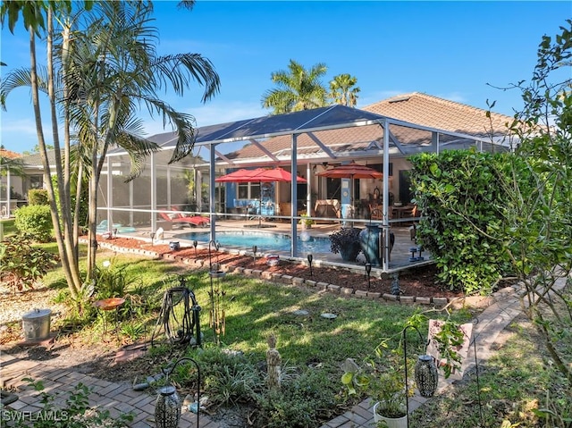 view of swimming pool with a lanai and a yard