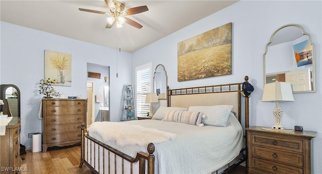 bedroom with hardwood / wood-style flooring, ceiling fan, and ensuite bath