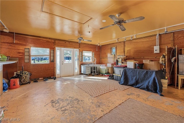 miscellaneous room featuring ceiling fan and wooden walls