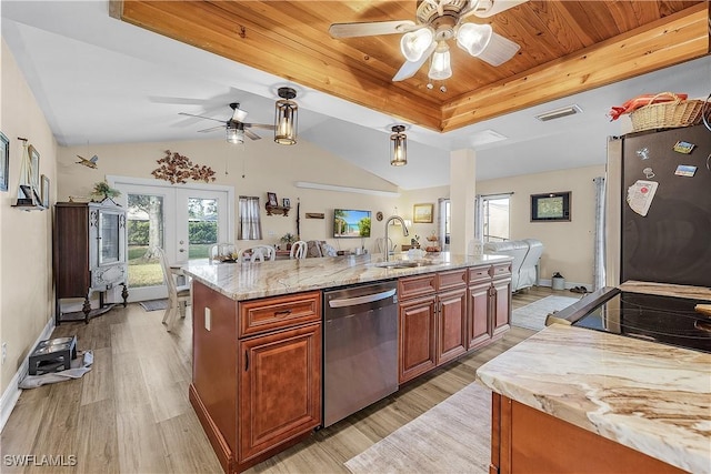 kitchen featuring sink, light hardwood / wood-style flooring, light stone countertops, appliances with stainless steel finishes, and a large island