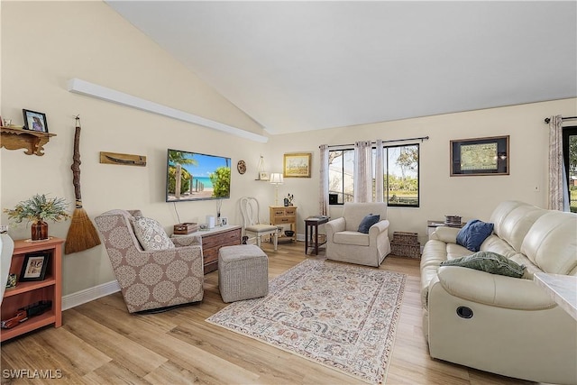 living room featuring high vaulted ceiling and light hardwood / wood-style flooring