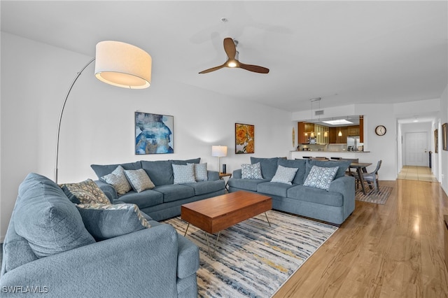 living room with ceiling fan and light wood-type flooring