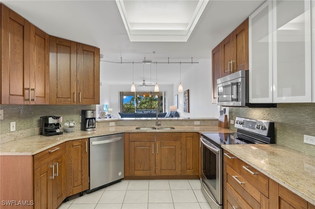 kitchen with pendant lighting, sink, light tile patterned floors, appliances with stainless steel finishes, and tasteful backsplash