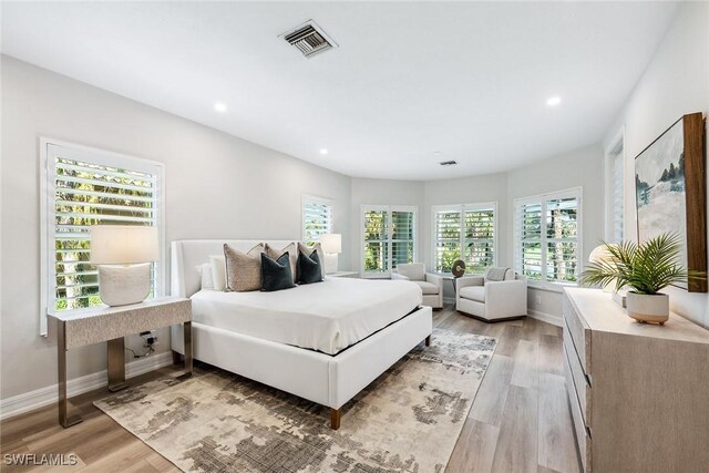 bedroom with multiple windows and light hardwood / wood-style flooring