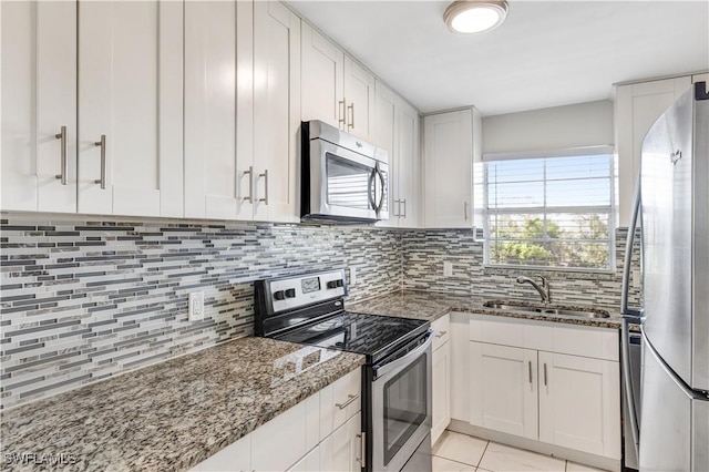 kitchen featuring sink, white cabinets, stone countertops, and appliances with stainless steel finishes