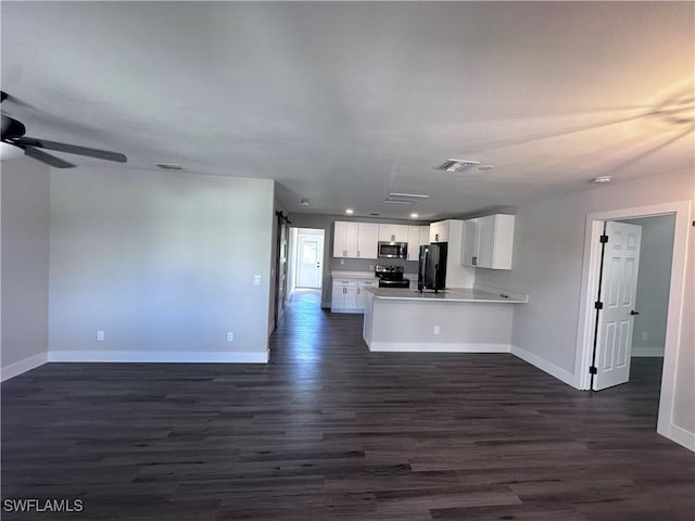 kitchen featuring kitchen peninsula, appliances with stainless steel finishes, ceiling fan, dark wood-type flooring, and white cabinets