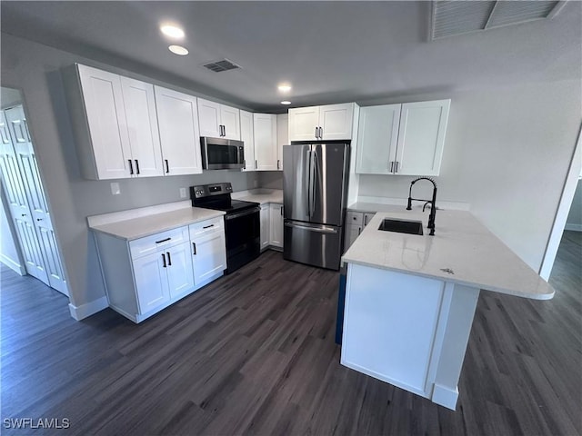 kitchen featuring kitchen peninsula, white cabinetry, sink, and appliances with stainless steel finishes