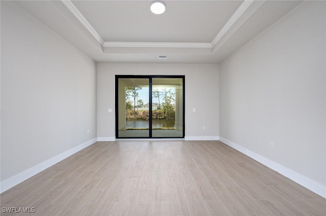 unfurnished room with a raised ceiling, crown molding, and light hardwood / wood-style flooring