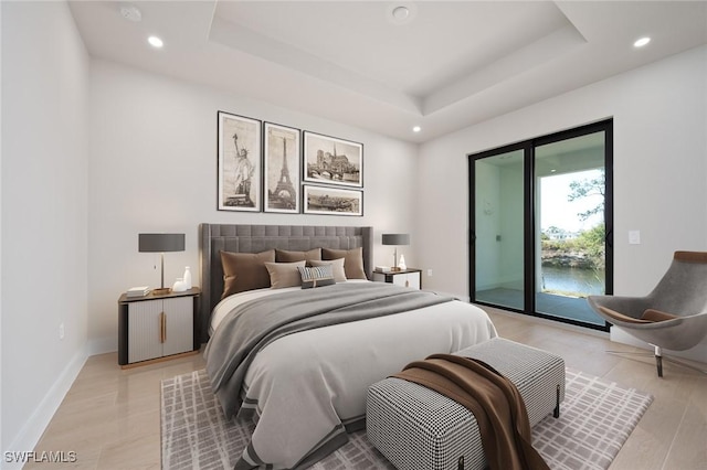 bedroom with a raised ceiling, access to exterior, and light hardwood / wood-style flooring