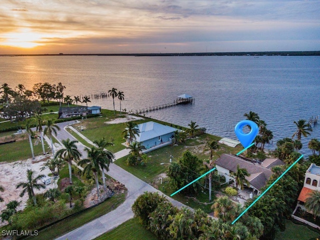 aerial view at dusk featuring a water view