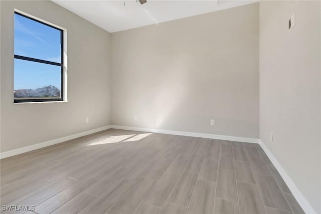 empty room featuring ceiling fan and light hardwood / wood-style floors