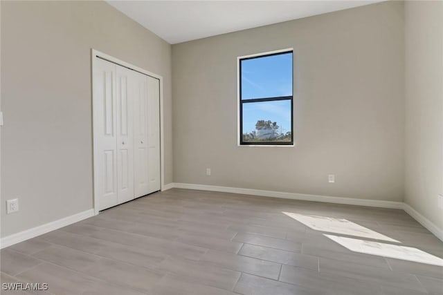 unfurnished bedroom with light hardwood / wood-style floors and a closet