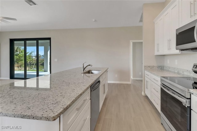 kitchen featuring white cabinetry, stainless steel appliances, and an island with sink