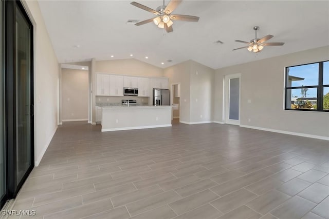 unfurnished living room with ceiling fan, light hardwood / wood-style flooring, and vaulted ceiling