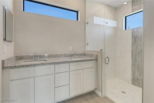 bathroom with vanity, a healthy amount of sunlight, and a shower with shower door