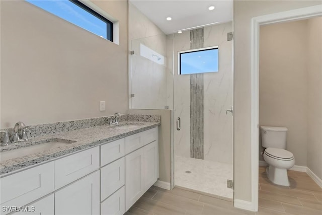 bathroom with vanity, toilet, and a shower with door