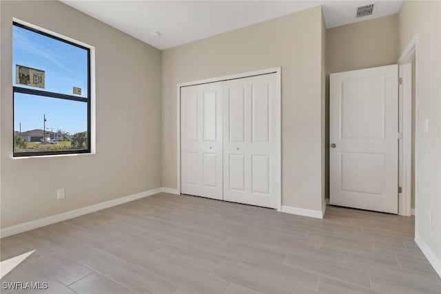 unfurnished bedroom featuring light hardwood / wood-style floors and a closet