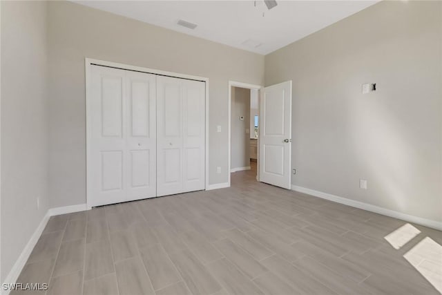 unfurnished bedroom featuring ceiling fan, a closet, and light hardwood / wood-style flooring