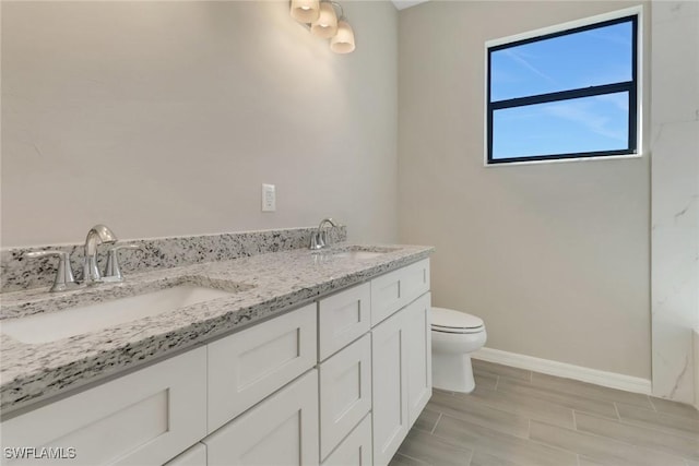 bathroom with hardwood / wood-style floors, vanity, and toilet