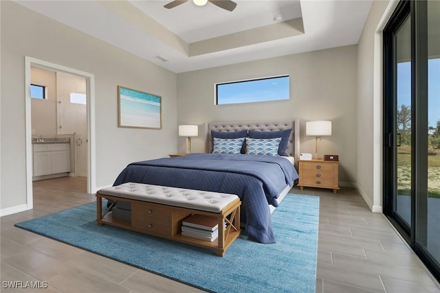 bedroom with access to exterior, a raised ceiling, ceiling fan, connected bathroom, and light hardwood / wood-style floors