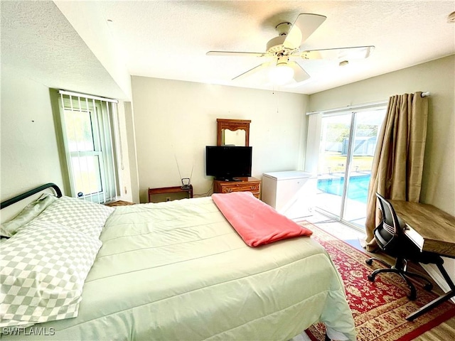 bedroom featuring ceiling fan, wood-type flooring, a textured ceiling, and access to outside