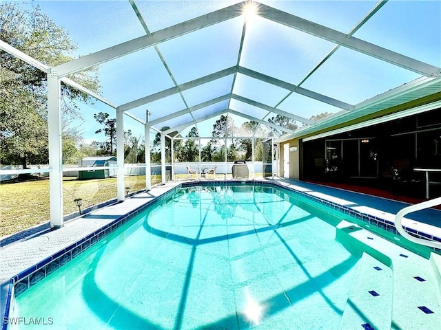 view of swimming pool with a lawn and a lanai