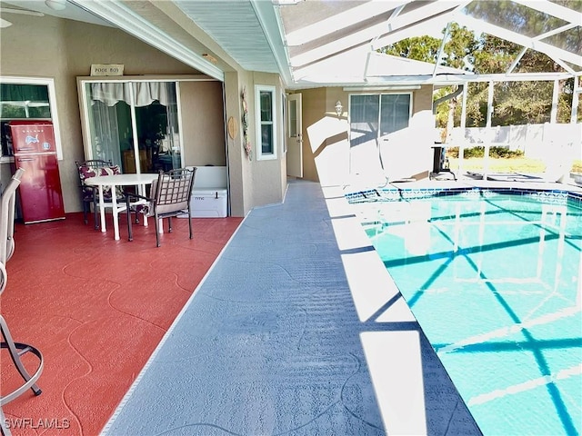 view of swimming pool with glass enclosure and a patio