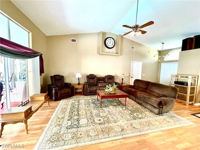 living room with ceiling fan, light wood-type flooring, and high vaulted ceiling