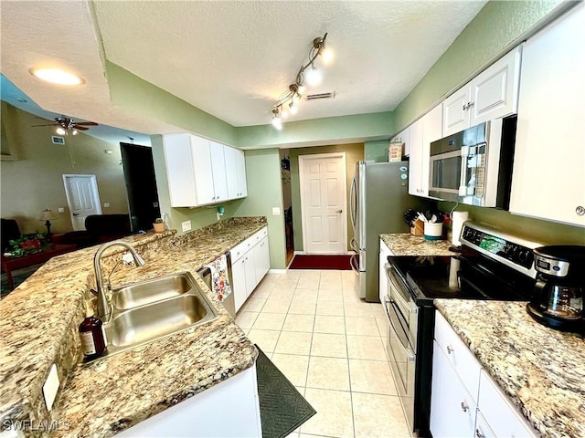 kitchen with a textured ceiling, white cabinetry, sink, and appliances with stainless steel finishes