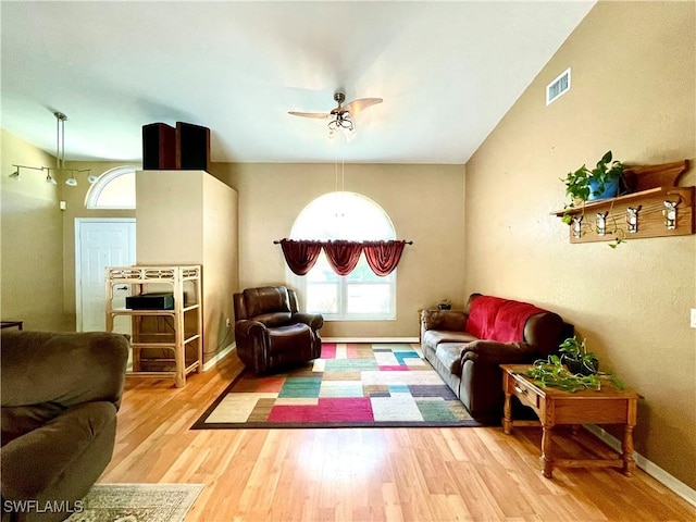 living room with hardwood / wood-style flooring, vaulted ceiling, and ceiling fan