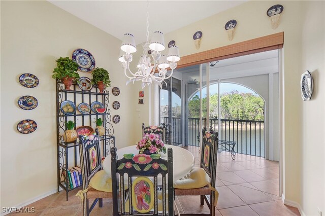 10801 Crooked River Rd Unit 203, Estero, FL 34135 - dining area featuring baseboards, a notable chandelier, and light tile patterned flooring