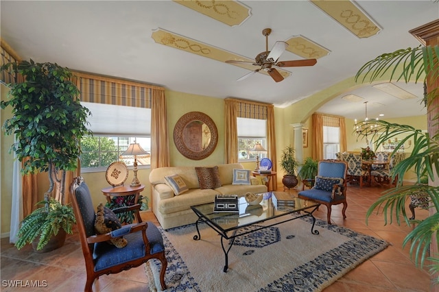 10801 Crooked River Rd Unit 203, Estero, FL 34135 - living room with ornate columns, ceiling fan with notable chandelier, arched walkways, and tile patterned floors