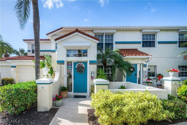10801 Crooked River Rd Unit 203, Estero, FL 34135 - view of front of home featuring an attached garage, a tiled roof, and stucco siding