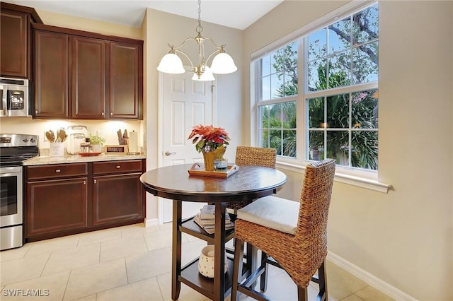 dining room with light tile patterned flooring and a notable chandelier