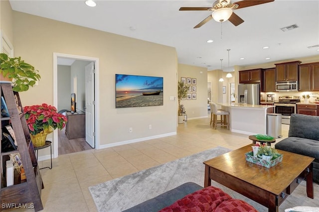 tiled living room featuring ceiling fan