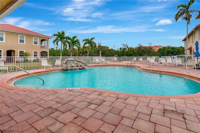 view of swimming pool with pool water feature and a patio area