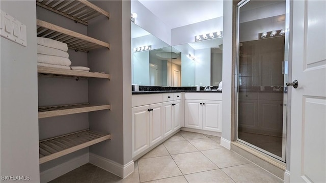 bathroom featuring tile patterned floors, a shower with door, and vanity