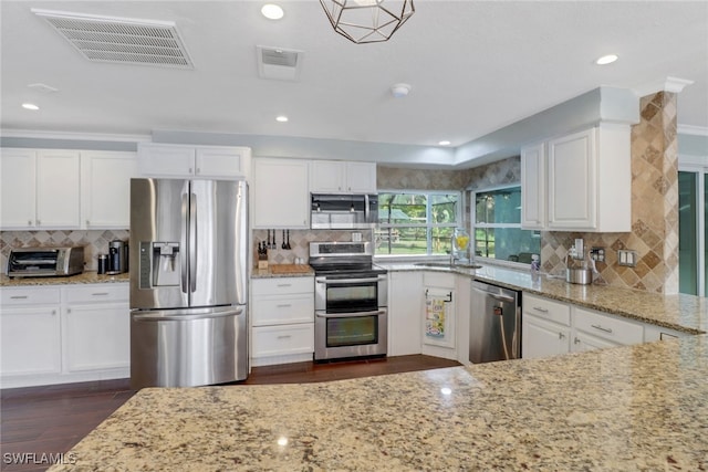 kitchen with white cabinets, stainless steel appliances, and light stone countertops