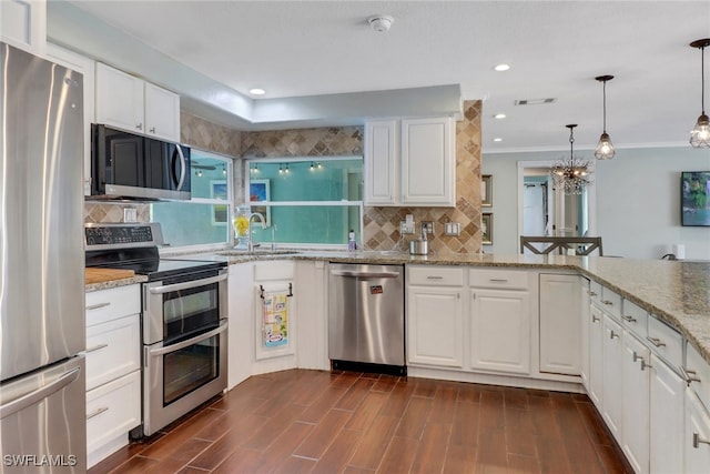 kitchen featuring sink, stainless steel appliances, light stone counters, pendant lighting, and white cabinets