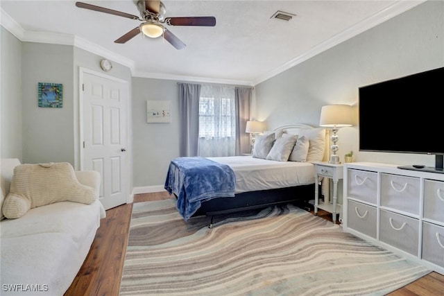 bedroom with ceiling fan, wood-type flooring, and crown molding