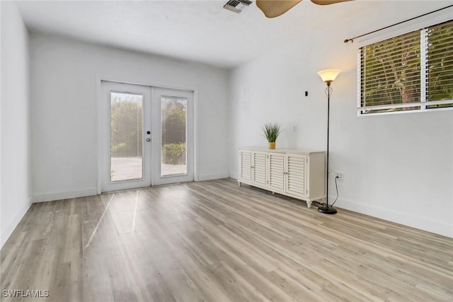 spare room with ceiling fan, french doors, and light wood-type flooring