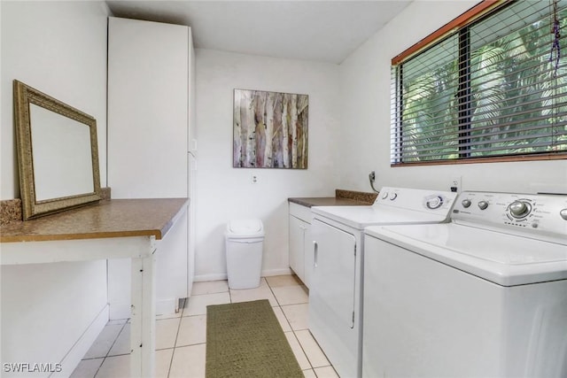 laundry room featuring light tile patterned flooring, cabinets, and independent washer and dryer